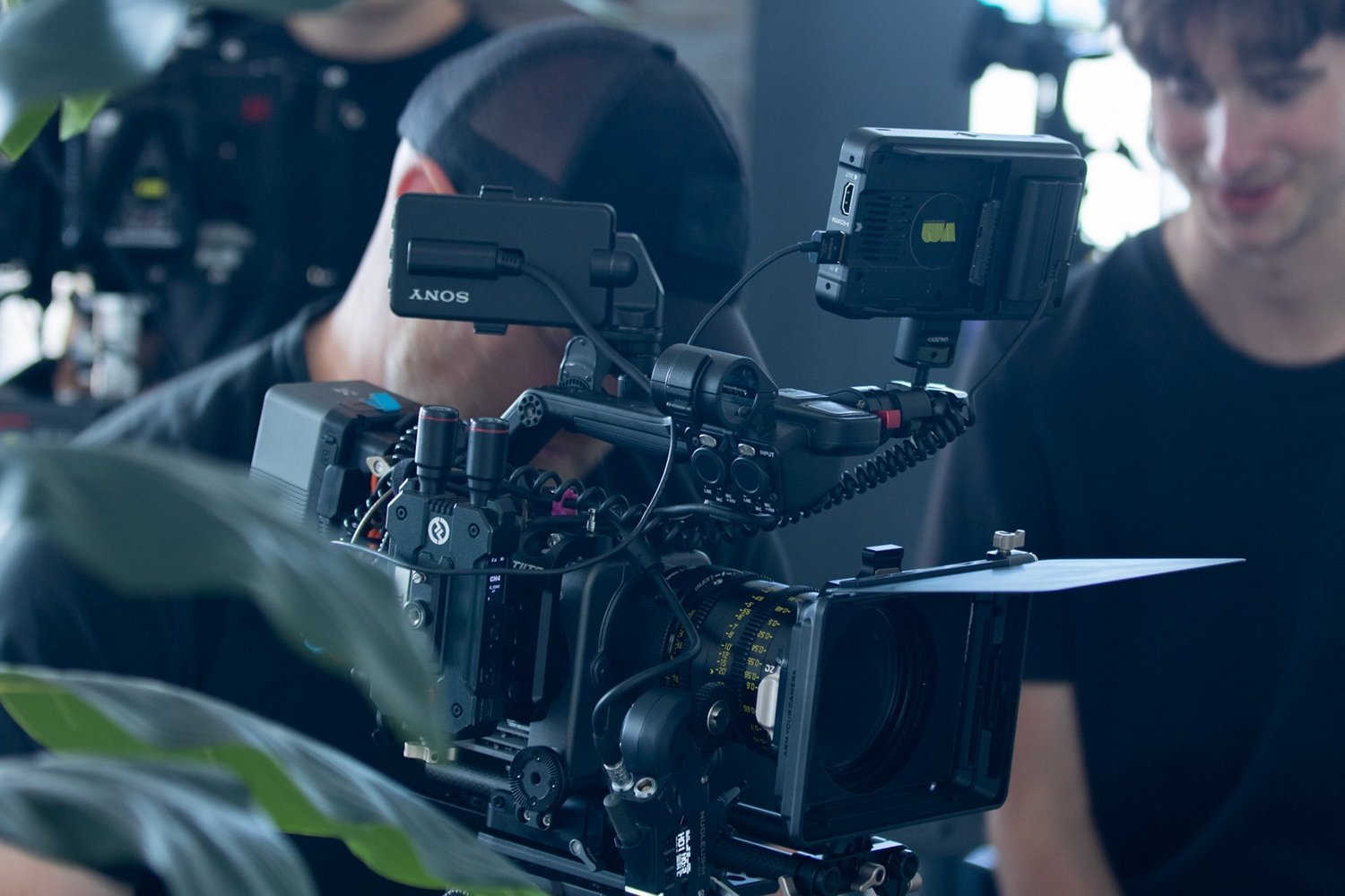 A built-up cinema camera package with matte box, monitors, and audio on a Nine Sixteen set